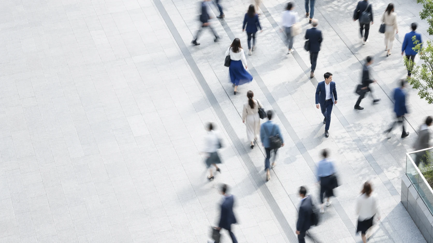 都市の広場を行き交う人々のイメージ